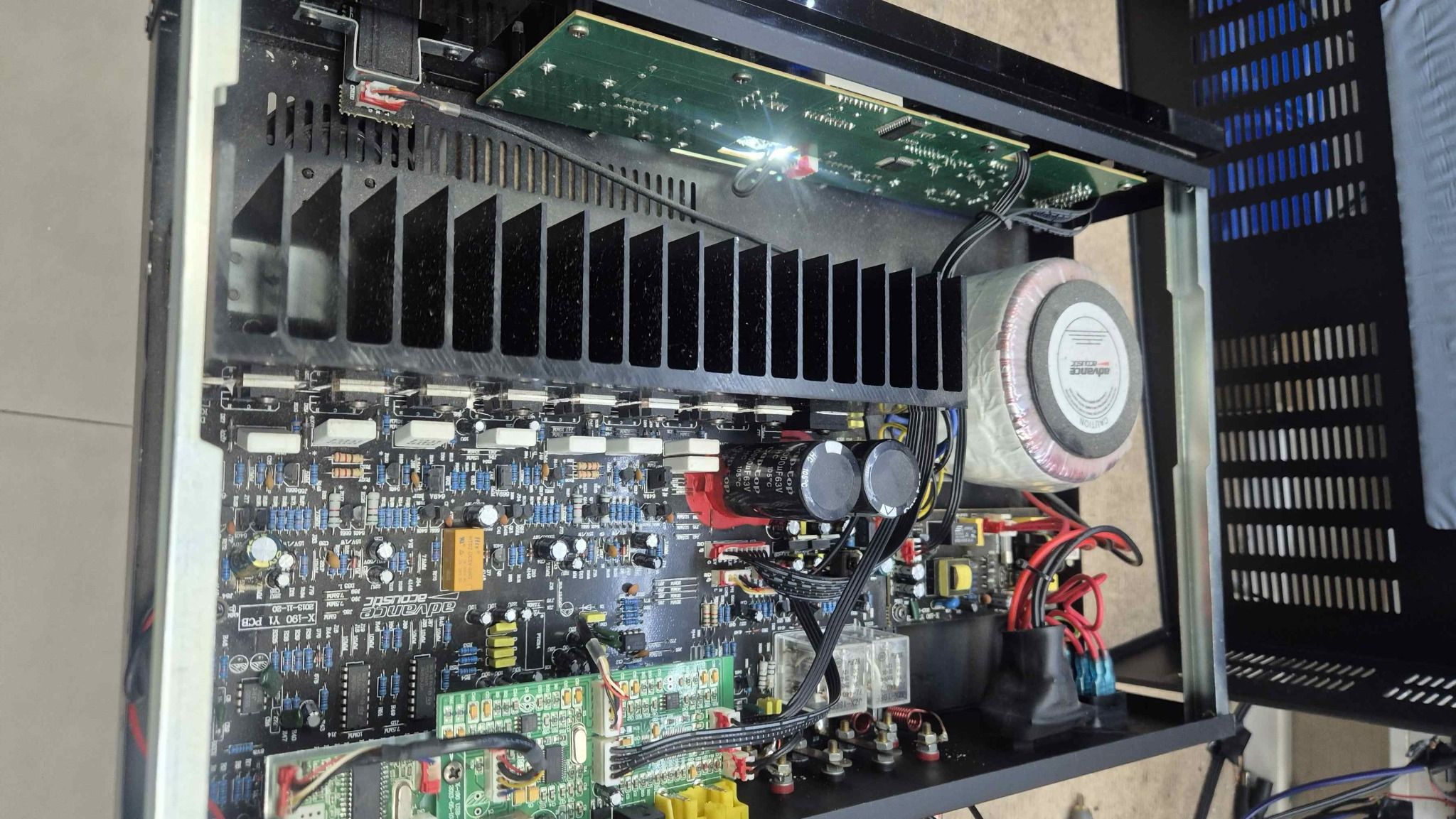 Interior del amplificador Advance Acoustic X-190 mostrando transformador toroidal, etapa de potencia y condensadores reemplazados